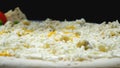 Chef pours cheese on pizza. Frame. Professional chef of Italian cuisine in gloves pours grated cheese on raw pizza