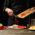 The chef pours hot chilli peppers into a plate. For cooking burritos, pizza, lettuce. A delicious and spicy food concept, Mexican Royalty Free Stock Photo