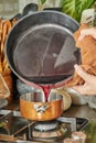 Chef pours the liquid in Copper Pot over low heat on the stove to make the sauce Royalty Free Stock Photo