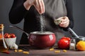 The chef preparations spaghetti and pasta, salt water, against a dark background, the concept of cooking. Woman salting water Royalty Free Stock Photo