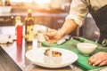 Chef prepare prawns fish tartare for dinner - Man garnishing a starter inside restaurant kitchen - Focus on left hand - Exclusive Royalty Free Stock Photo