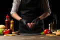 The chef prepares the cutlet with fresh ground beef, holding in the form of a heart, ingredients on the background, cooking a