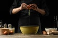 The chef prepares the dough for bread, pizza and sweets. The concept of food. On a black background, freezing in motion. Book of Royalty Free Stock Photo