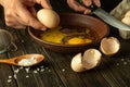 The chef prepares an egg omelette for breakfast. Work environment on the kitchen table. Egg in the cook hand Royalty Free Stock Photo