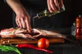 The chef prepares fresh fish bighead carp with add oil. Preparing to cook fish food. Working environment in restaurant or cafe