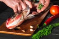 The chef prepares fresh fish bighead carp with add spice. Preparing to cook fish food. Working environment in restaurant or cafe Royalty Free Stock Photo