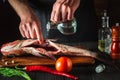 The chef prepares fresh fish bighead carp with add vinegar. Preparation for cooking herring. Working environment in restaurant or