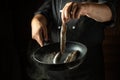 Chef prepares fried capelin in the kitchen. Concept on black background of service in restaurant or hotel. Advertising space