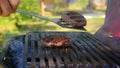Chef prepares juicy meat for burgers on barbecue grill with an iron spatula. Cooking meat on open fire for eating
