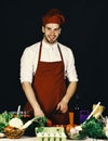 Chef prepares. Man in cook uniform chops pepper. Chef with happy face Royalty Free Stock Photo