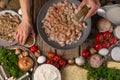 The chef prepares pizza with minced meat and mushrooms. In the photo, the cooking process. The chef adds spices to the filling. A Royalty Free Stock Photo