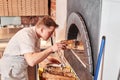 The chef prepares pizza in a neapolitan pizzeria. Cook in a apron in the kitchen with a shovel in his hands. boxes for Royalty Free Stock Photo