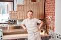 The chef prepares pizza in a neapolitan pizzeria. Cook in a apron in the kitchen with a shovel in his hands. boxes for Royalty Free Stock Photo