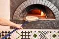 The chef prepares pizza. Raw pizza ready to bake. Cook in a apron in the kitchen. with a shovel in his hands. boxes for Royalty Free Stock Photo