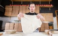 The chef prepares pizza. Raw pizza ready to bake. Cook in a blue apron in the kitchen. with a shovel in his hands. boxes Royalty Free Stock Photo