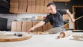 The chef prepares pizza. Raw pizza ready to bake. Cook in a blue apron in the kitchen. with a shovel in his hands. boxes Royalty Free Stock Photo