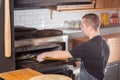 The chef prepares pizza. Raw pizza ready to bake. Cook in a blue apron in the kitchen. with a shovel in his hands. boxes Royalty Free Stock Photo