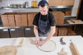 The chef prepares pizza. Raw pizza ready to bake. Cook in a blue apron in the kitchen. with a shovel in his hands. boxes Royalty Free Stock Photo