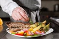 The chef prepares in the restaurant. Grilled rack of lamb with fried potatoes and fresh vegetables. closeup Royalty Free Stock Photo