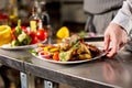 The chef prepares in the restaurant. Grilled rack of lamb with fried potatoes and fresh vegetables Royalty Free Stock Photo