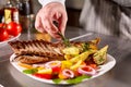 The chef prepares in the restaurant. Grilled rack of lamb with fried potatoes and fresh vegetables Royalty Free Stock Photo