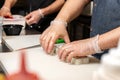 The chef prepares rolls with rice on the outside