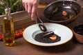 Chef prepares seafood ,mussels, shrimp puts food in a white plate