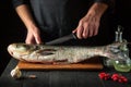 The chef prepares silver carp herring in the restaurant kitchen. Preparation for cutting fish with a knife. Work environment on Royalty Free Stock Photo