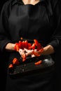 The chef prepares tomato sauce, fries tomatoes, cherry tomatoes in a frying pan, freezes, pasta, pizza. process steps in the