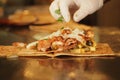 Chef preparing a chicken wrap with fresh toppings Royalty Free Stock Photo