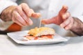 Chef preparing delicious typical Spanish food, ham tapa or Pintxo of Jamon iberico.