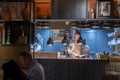 Chef preparing food in illuminated kitchen at restaurant in resort