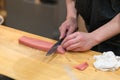Chef preparing a fresh Tuna on a cutting board for otoro sushi