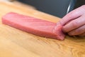 Chef preparing a fresh Tuna on a cutting board for otoro sushi