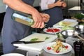 Chef preparing fried meat with salad for serving in restaurant kitchen Royalty Free Stock Photo