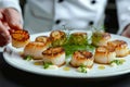 Chef preparing grilled scallops in creamy lemon butter or spicy cajun sauce with herbs