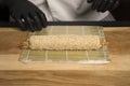 Chef preparing Japanese Ebi Tempura sushi roll with black tiger shrimp inside. Working in protective gloves. Professional Cooking Royalty Free Stock Photo