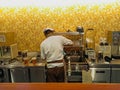 A chef preparing a meal behind his counter