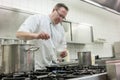 Chef preparing pancake dessert pouring dough into pan in kitchen