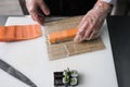 Chef preparing philadelphia sushi rolls salmon