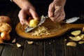 The chef is preparing potato pancakes on the kitchen table. Close-up of a cook hands grating potatoes Royalty Free Stock Photo