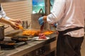 The chef preparing beef and grilling shrimp in restaurant kitchen