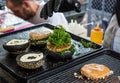 Chef preparing tasty burgers at outdoor stand. Royalty Free Stock Photo