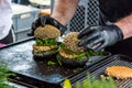 Chef preparing tasty burgers at outdoor stand. Royalty Free Stock Photo