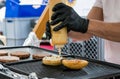 Chef preparing tasty burgers at outdoor stand. Royalty Free Stock Photo