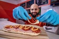 Chef preparing tasty sub sandwich from fresh ingredients. Royalty Free Stock Photo