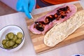 Chef preparing tasty sub sandwich from fresh ingredients. Royalty Free Stock Photo