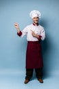 Chef presenting something over light blue background Royalty Free Stock Photo
