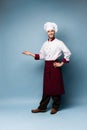 Chef presenting something over light blue background Royalty Free Stock Photo