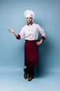 Chef presenting something over light blue background Royalty Free Stock Photo